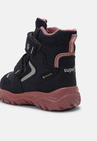 Dunkelblauer Winterstiefel für Kinder mit pinkfarbener Sohle und Fütterung, zwei Klettverschlüssen, reflektierenden Details und Gore-Tex wasserdichtem Etikett.