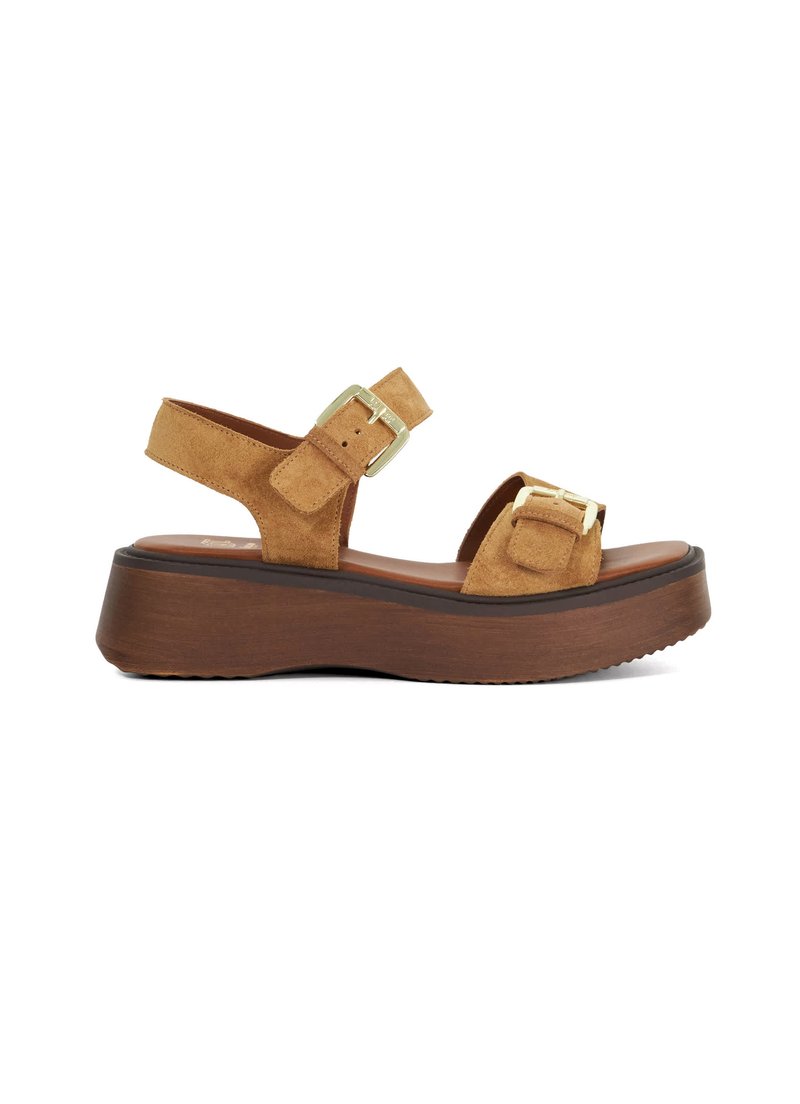 Tan suède platform sandalen met verstelbare enkelband, gespsaccenten en een houten textuurzool. Platter hak met een lichte kromming.