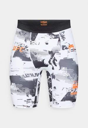 Kompresjonsshorts i hvitt og svart med abstrakte mønstre og oransje detaljer. Elastisk midjebånd med logotrykk.