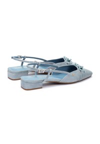 Chaussures en suede bleu clair à talon bloc, à bout pointu, avec un détail en nœud sur le devant et une bride ajustable à la cheville.
