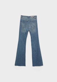 Jeans de campana azules con un lavado desgastado, que presentan un diseño clásico de cinco bolsillos, detalles de costura y un parche de cuero en la cinturilla.