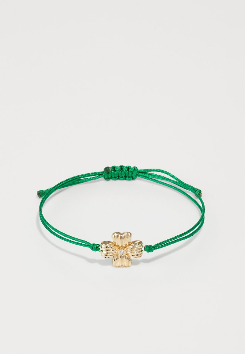 Green adjustable cord bracelet featuring a gold flower-shaped charm with ridged details and a central clear crystal.