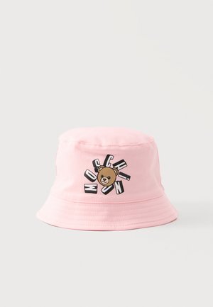 Różowy kapelusz typu bucket z twarzą misia i napisem "MOSCHINO" wyróżnionym pogrubionymi literami wokół misia z przodu.