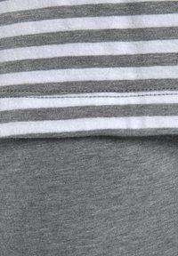 Grauer Baumwollstoff mit horizontalen weißen und grauen Streifen oben, glatte Textur mit einem kontrastierenden gemusterten Abschnitt darunter.