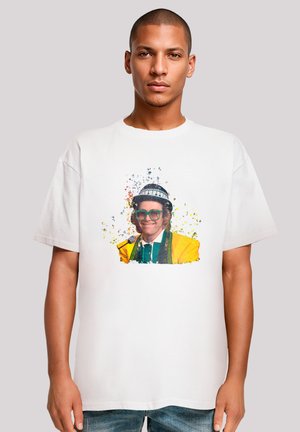 White cotton t-shirt featuring a graphic print of a smiling man with glasses and a hat, surrounded by colorful splatter accents.