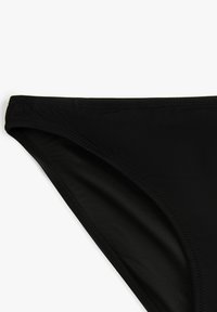 Parte inferior de bikini negra con una textura suave, presenta un corte clásico y tiene una cinturilla elástica plana y costuras limpias a lo largo de los bordes.