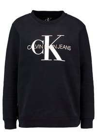 Černá mikina vyrobená z bavlněné směsi s dlouhými rukávy, kulatým výstřihem a velkým bílým logem "CK" s textem "CALVIN KLEIN JEANS" pod ním.