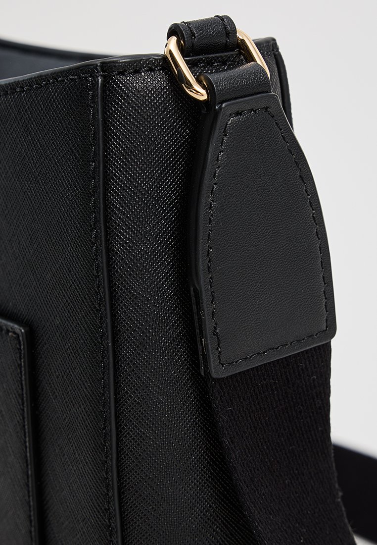 Schwarze Handtasche mit strukturiertem Material, goldfarbener Metallhardware und einem glatten Lederhenkel. Kompakte rechteckige Form.