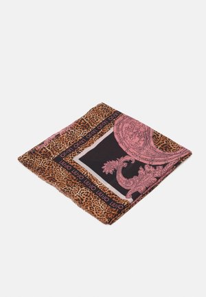 Foulard carré avec bordure à imprimé léopard et motif floral orné rose sur fond noir, plié sur une surface blanche.