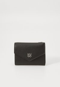 Billetera de cuero negro con un acabado texturizado, que presenta una solapa triangular y el logo plateado "HUGO" en la parte frontal. Detalle de cremallera en el lateral.
