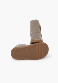 Beige enkellaarzen met een gestructureerd bovenwerk, een ronde neus en een verstevigde hak. De rubberen zool heeft horizontale groeven voor grip.