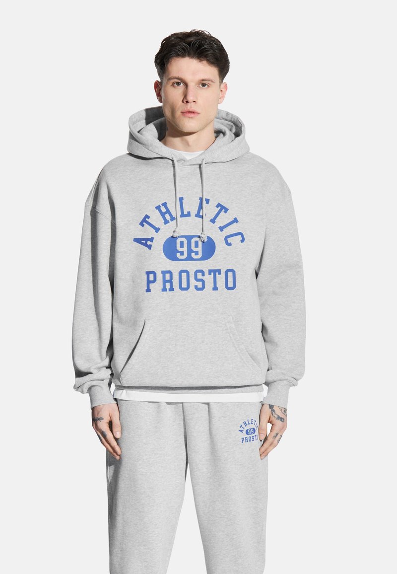 Szary sweatshirt z kieszenią kangurką, kapturem na sznurek, niebieskim napisem 'ATHLETIC 99 PROSTO', w zestawie z dopasowanymi dresami z niebieskim logo.