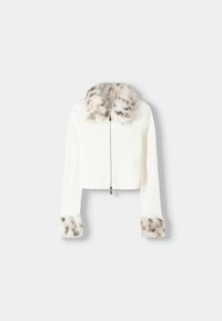 Cropped white jacket with a zip front, featuring a soft faux fur collar and fur accents at the cuffs, creating a textured contrast.