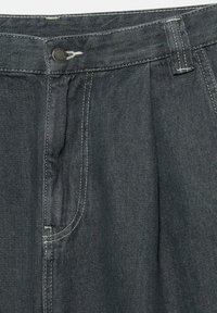 Dark gray denim trousers featuring a pleated front, zip and button closure, and contrasting white stitching. Includes a side pocket for utility.