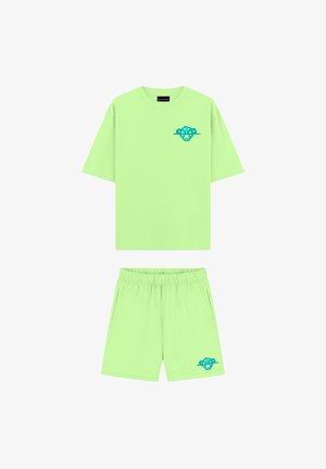 Felgroene T-shirt met korte mouwen en bijpassende shorts met blauwe gestileerde leeuwenkoppen op de borst en het been.
