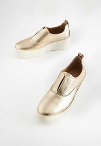 Scarpe slip-on metalliche dorate con tomaia testurizzata, design elegante e suola a piattaforma bianca. Presentano pannelli elasticizzati e un primo alla caviglia.