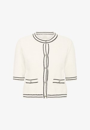 Cardigan blanc texturé avec bordure noire, manches courtes, encolure ronde et deux poches frontales. Fermeture à boutons avec accents décoratifs.