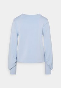 Top de manga larga azul claro, hecho de una tela suave, con mangas ligeramente fruncidas y un escote redondeado, con un diseño recortado.