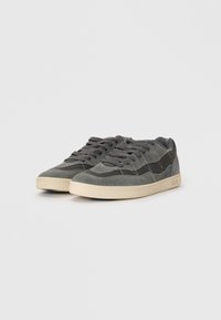Gray suede sneakers with mesh accents, textured surfaces, and beige rubber soles. Features laces and subtle stitching details.