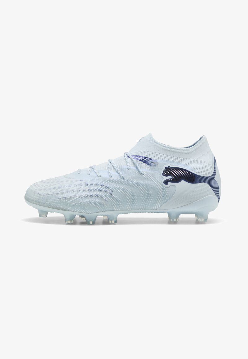 Chaussure de football blanche avec une tige texturée, des accents bleu clair, des lacets et un logo Puma noir sur le côté, conçue pour un jeu sur terrain ferme.