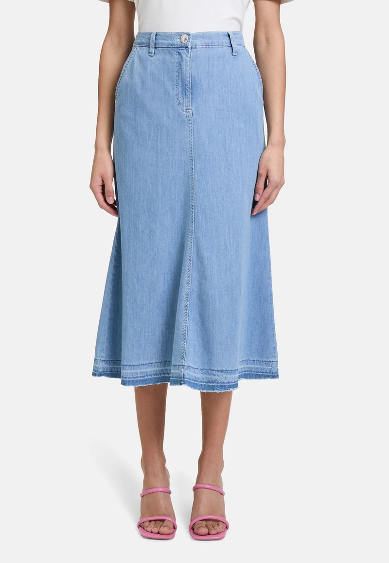 Denim midi rok in lichtblauw, met een knoopsluiting aan de voorkant, twee zijzakken en een rafelige zoom. Gecombineerd met roze sandalen met bandjes.
