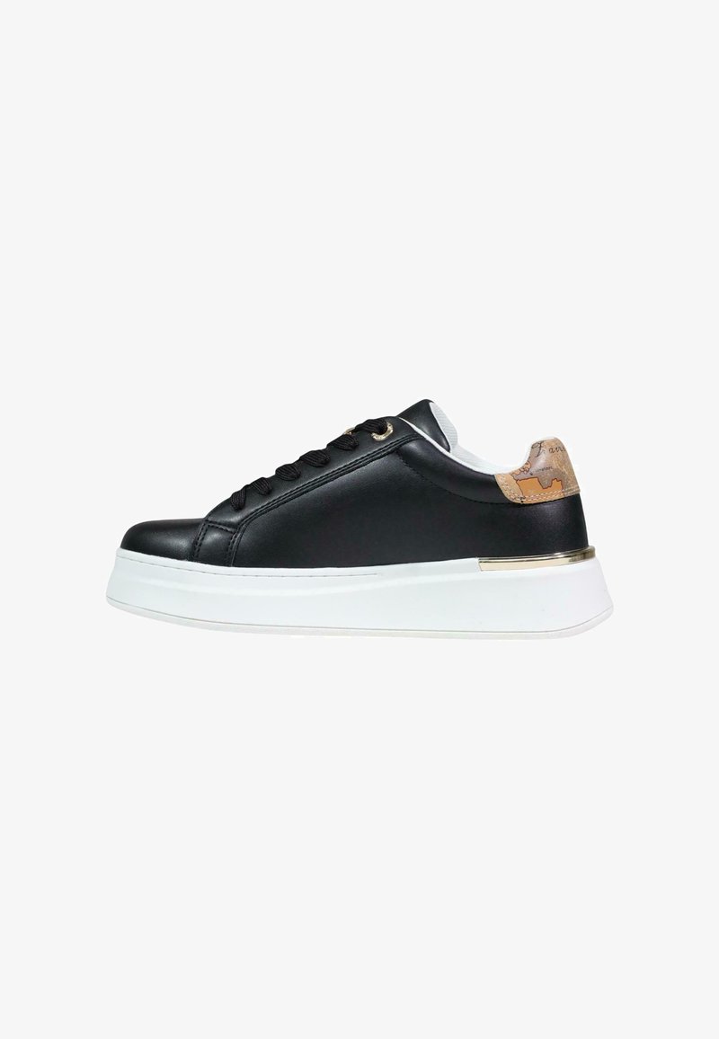 Zapatilla negra de perfil bajo con suela blanca gruesa, cordones negros y lengüeta del talón en tono marrón claro con un detalle dorado sobre la suela.