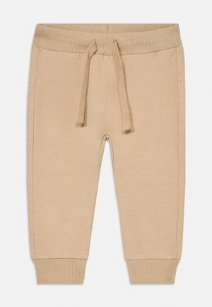Calças jogger bege feitas de um tecido suave, com uma cintura canelada, cordão e punhos ajustados. Inclui bolsos laterais para maior praticidade.