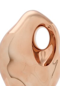 Kopparmetallisk objekt med en slät, organisk form, med en cirkulär urtagning. Ytan reflekterar ljus med en blank finish.