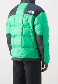 Nafukovací bunda ve světlé zelené a tmavě šedé barvě, s prošívaným vzorem, vysokým límcem a logem na horní části zad. Texturovaná tkanina.