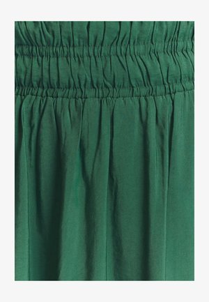 Zelená látková sukně se shromážděným elastickým pasem, která se vyznačuje hladkou, lehkou texturou a jemným splýváním.