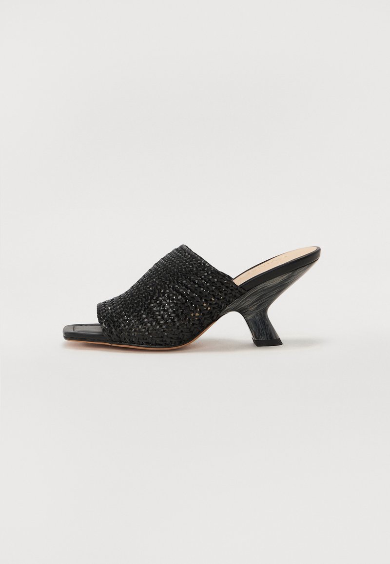 Sandal cu talpă întredată de culoare neagră, cu vârf deschis, accentuată de un toc bloc curbat și o suprafață netedă, texturată. Material durabil cu un design elegant.