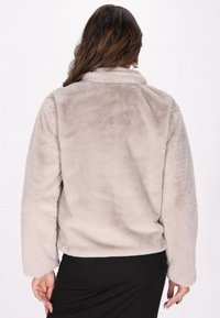 Giacca in pelliccia sintetica di colore grigio chiaro con una texture morbida, dotata di colletto e maniche lunghe. La vista posteriore mostra una vestibilità comoda e un orlo arcuato.