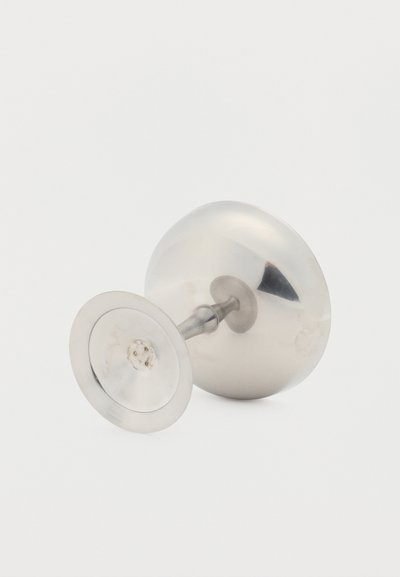 Izpopolnjen srebrni zapestni gumb s okroglim, izbočenim sprednjim delom in ravnim, krožnim zadnjim delom na svetli podlagi.