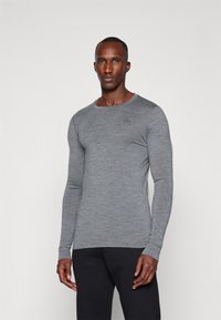 Camisa cinza de manga longa feita de um tecido texturizado, com um decote redondo e um discreto detalhe de logo no peito.