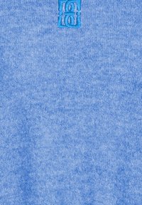 Tissu tricoté bleu clair avec une finition texturée ; comporte un logo brodé dans un bleu contrastant. Design doux et décontracté.