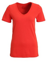 Punainen Nike Dri-FIT t-paita, jossa on lyhyet hihat, V-kaula-aukko, pehmeä tekstuuri ja istuva leikkaus. Edessä pieni logo.