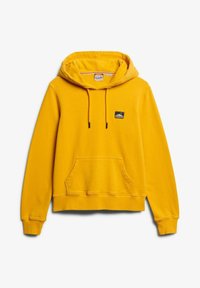 Geel hoodie met een voorzak, verstelbare trekkoorden en een klein merkpatch op de borst. Zachte stoftextuur.