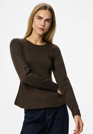 Brun langærmet top med rund halsudskæring, tætsiddende design og tekstureret stof. Har sidelapper for form, parret med denim jeans.