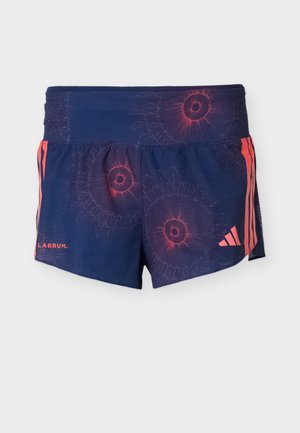 Tmavě modré sportovní kraťasy s červenými kruhovými vzory, červeným logem Adidas na pravé nohavici, červenými bočními pruhy a nápisem "LABRUM" na levé nohavici.