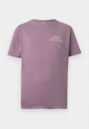 Lilla bomulds T-shirt med rund halsudskæring og korte ærmer. Har "OBEY STUDIOS" broderet i hvidt på venstre bryst.