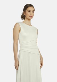 Witte, mouwloze jurk met een getailleerd lijfje en gedrapeerde taille-details, vloeiende stof en een zachte textuur. Eenvoudig, elegant ontwerp.