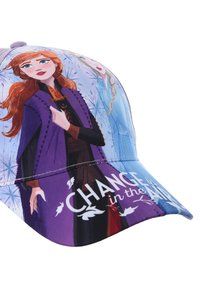 Casquette violette avec des personnages animés, l'un ayant de longs cheveux bruns portant une cape noire et violette, avec le texte "CHANGEMENT EN VUE" sur la visière.