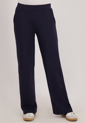 Marineblauwe, wijde broek van zacht, rekbaar materiaal, met een gladde, platte tailleband en zonder zichtbare zakken.