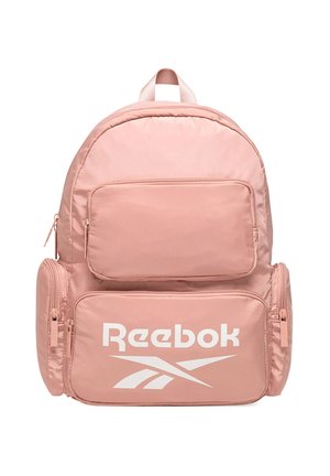 Mochila rosa de Reebok con varios compartimentos con cremallera y un gran logo blanco de Reebok en el bolsillo delantero.