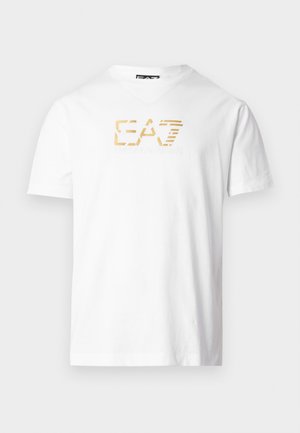 White cotton t-shirt with a V-neckline. Features a gold E.A.7 logo printed on the chest, creating a textured visual detail.
