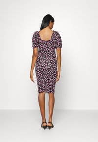 Vestido justo preto com padrão floral rosa. Mangas curtas bufantes, decote quadrado nas costas, comprimento até ao joelho, tecido elástico.