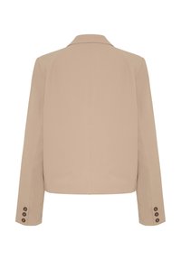 Béžový blazer s klopovým límcem a dlouhými rukávy. Má sedm hnědých knoflíčků na každém manžetě a upravený, strukturovaný střih.