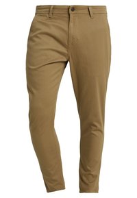 Pantaloni beige su misura con una texture liscia, vestibilità slim e tasche frontali. Presentano una chiusura con bottone e zip.