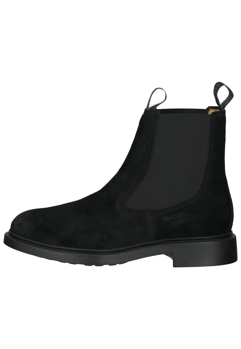 Bottine Chelsea en daim noir avec des panneaux latéraux élastiques, une languette et une semelle en caoutchouc lisse. Design simple sans motifs visibles.