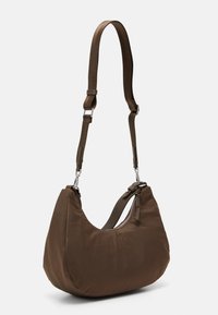 Sac hobo en nylon marron avec une forme courbée, bandoulière en tissu réglable, quincaillerie en métal argenté et détail de fermeture éclair sur le côté. Texture lisse.